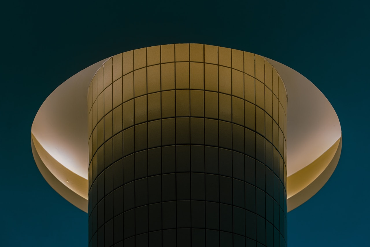 A cylindrical tower with tiled walls illuminated by a glowing circular light fixture, Ultra