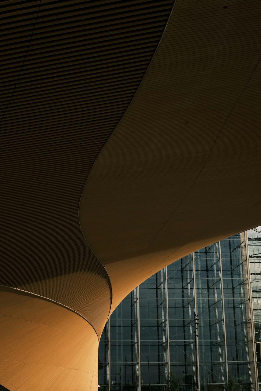 A large building with a curved roof next to a tall building, Ultra