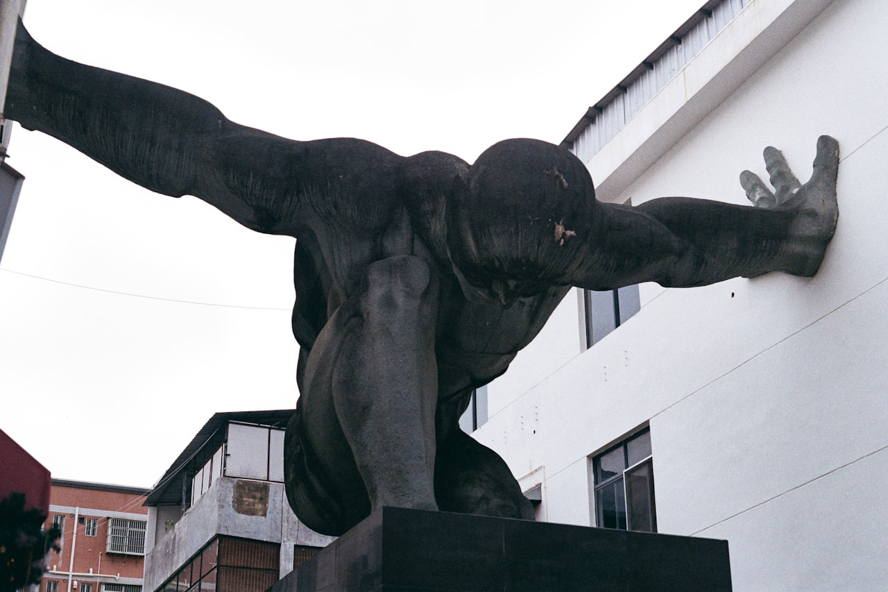 A large statue of a man pushing a wall, Ultra