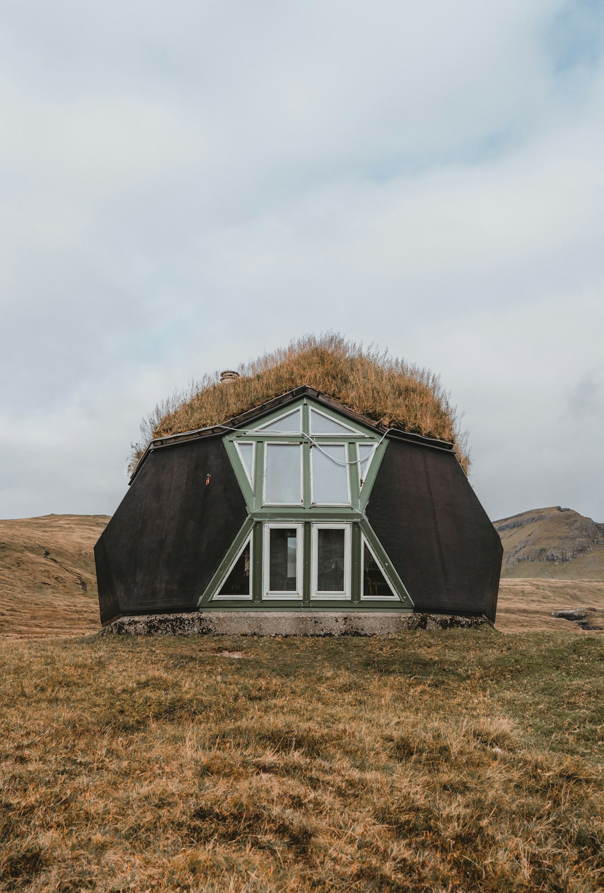 A modern geometric house with a grass roof in a grassy landscape, Ultra