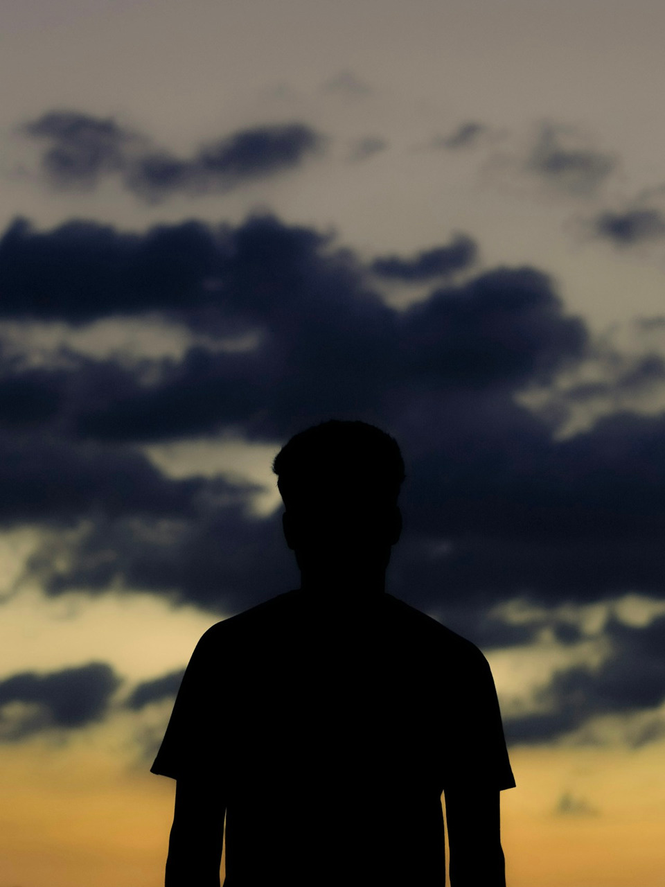 A silhouette stands before a cloudy sunset, Ultra
