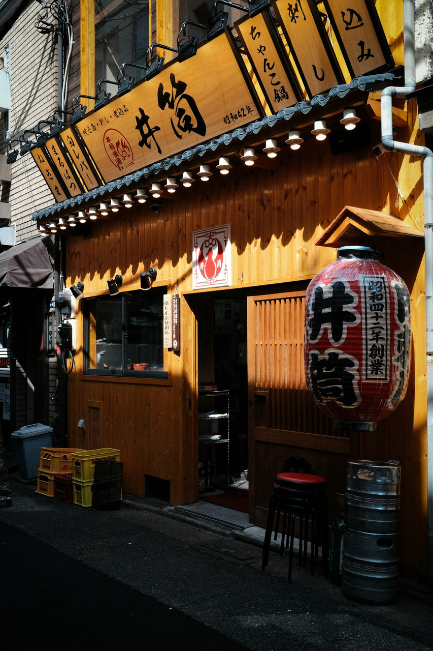An izakaya with a wooden facade and a red paper lantern in Taito City, Ultra