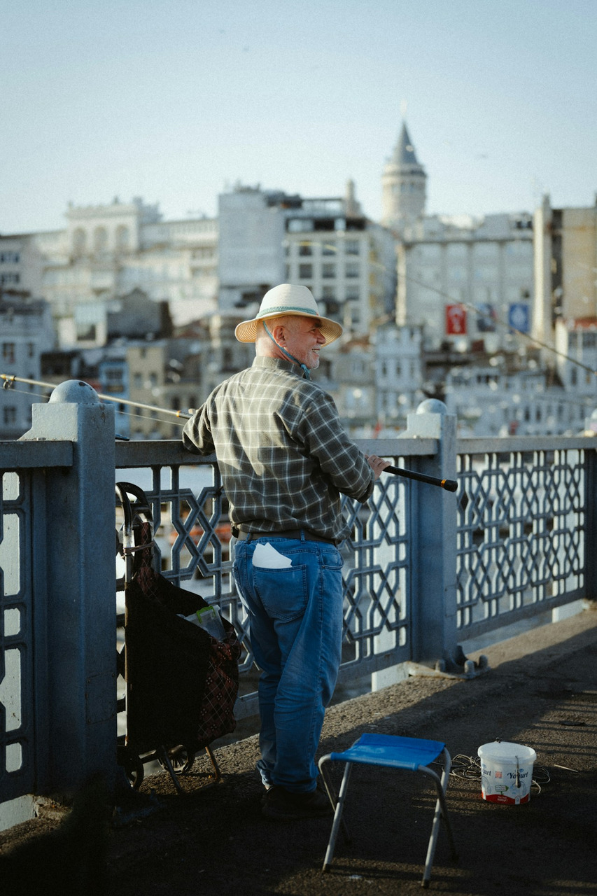 Man fishing on a bridge with galata tower in background, Ultra