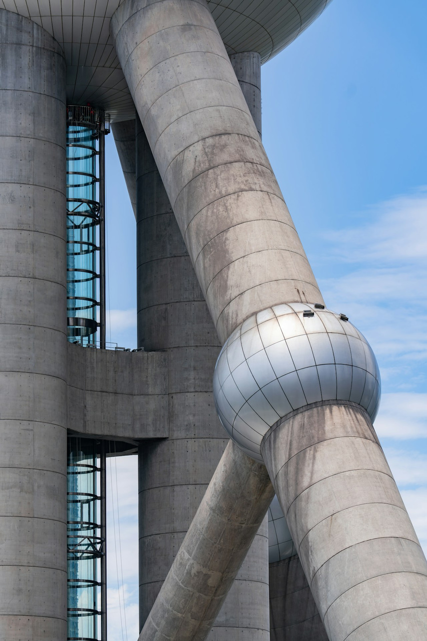 Modern building's concrete pillars and spherical joint against blue sky, Ultra