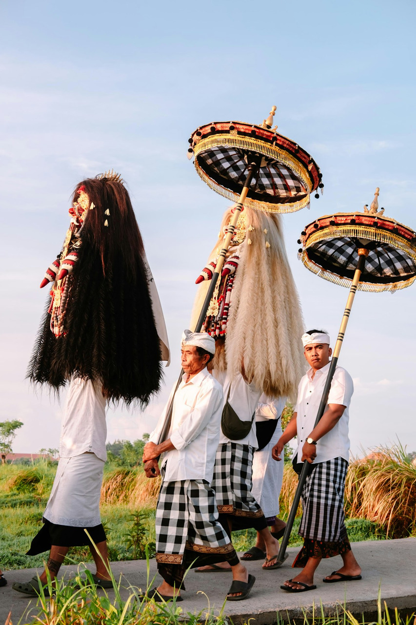 People in traditional balinese attire carrying ceremonial figures, Ultra