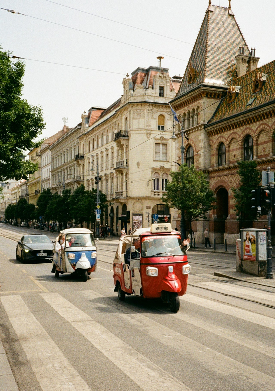 Three-wheeled vehicles drive down a european street, Ultra