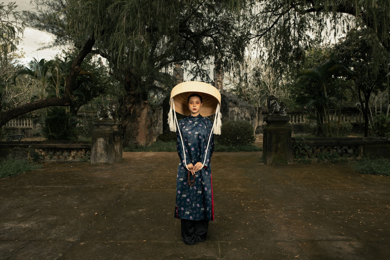 Vietnamese woman in ao dai and non la standing outdoors, Ultra